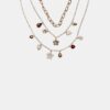 Set med 3 halsband med flera berlocker