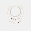 Set med 3 halsband med flera berlocker
