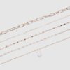 Set med 5 halsband med rosa stenar